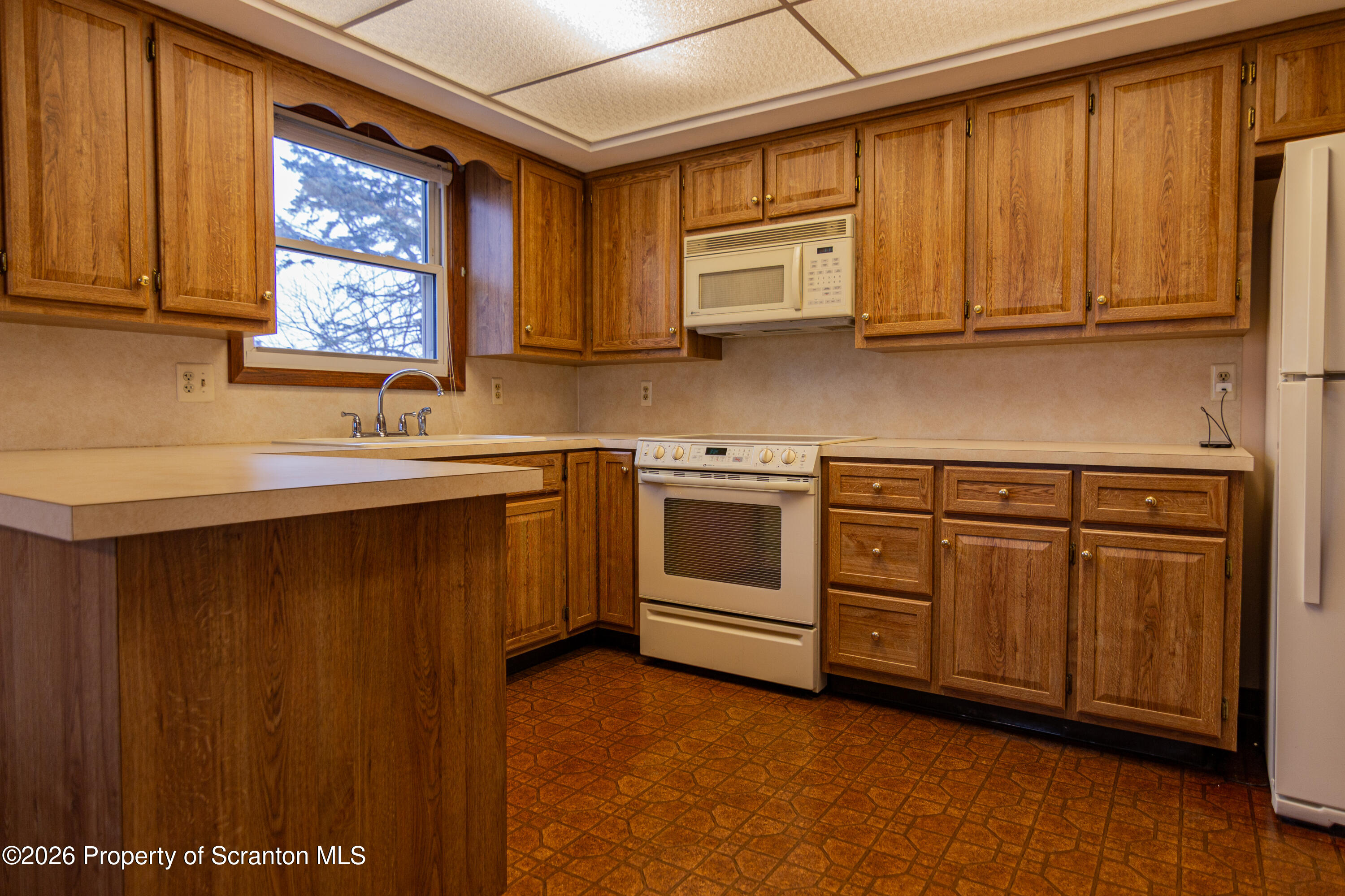 1215 Mine Street Old Forge, PA 18518 - Photo 17 of 34 a kitchen with white cabinets a sink and dishwasher
