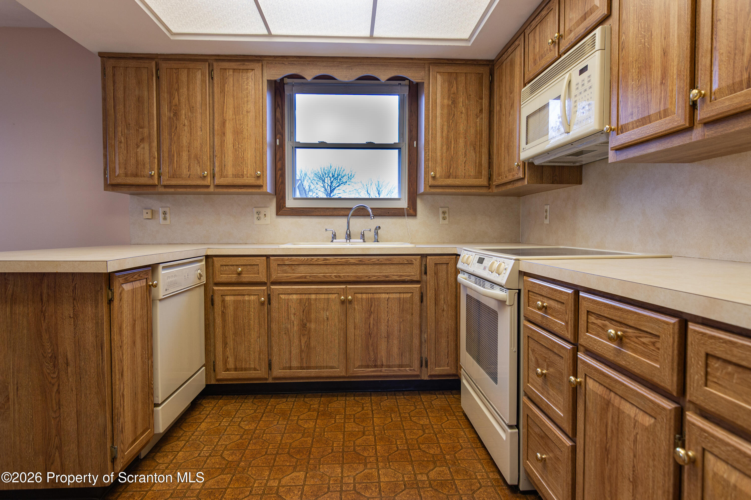 1215 Mine Street Old Forge, PA 18518 - Photo 20 of 34 a kitchen with stainless steel appliances granite countertop a sink and cabinets with wooden floor