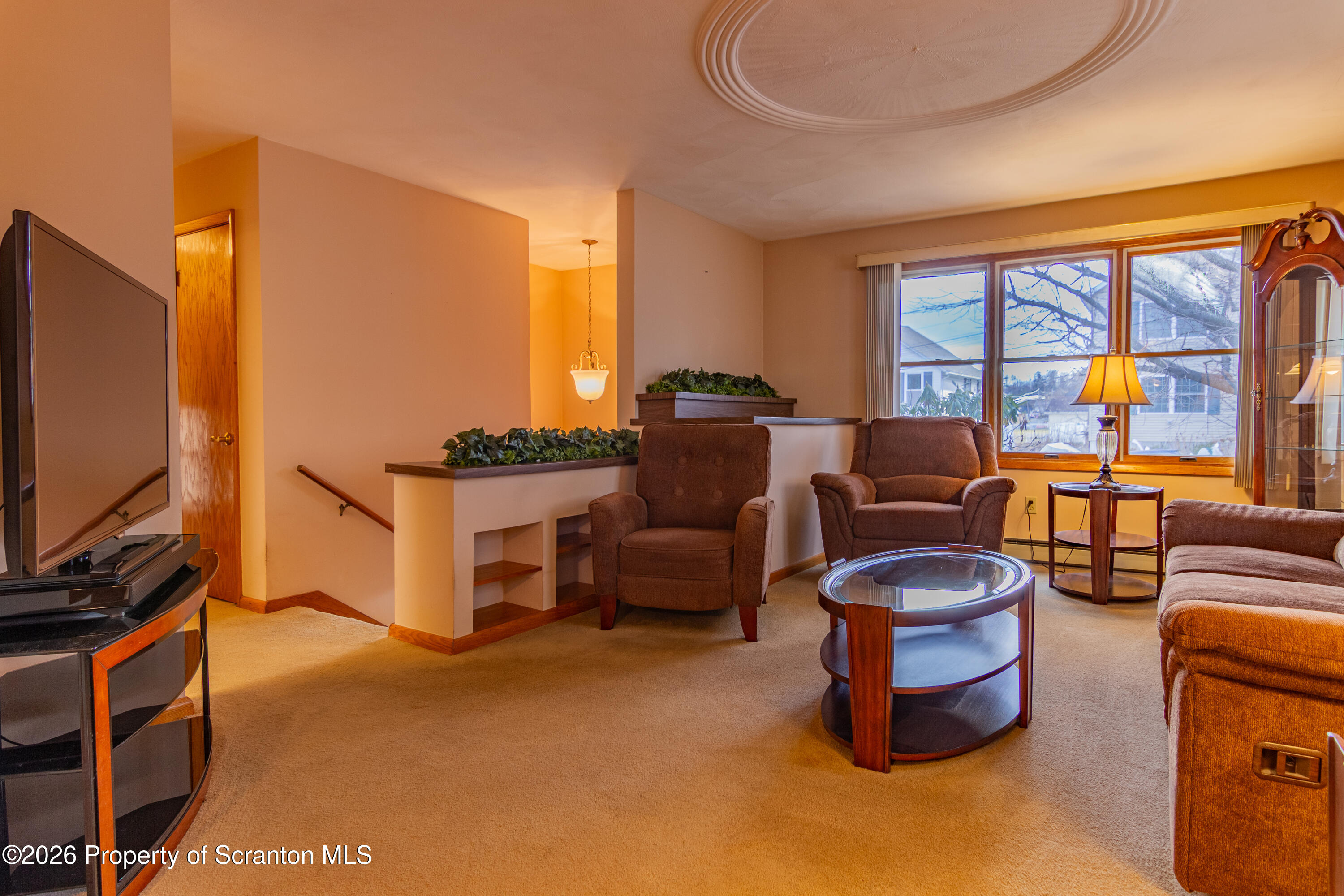 1215 Mine Street Old Forge, PA 18518 - Photo 23 of 34 a living room with furniture a flat screen tv and a floor to ceiling window