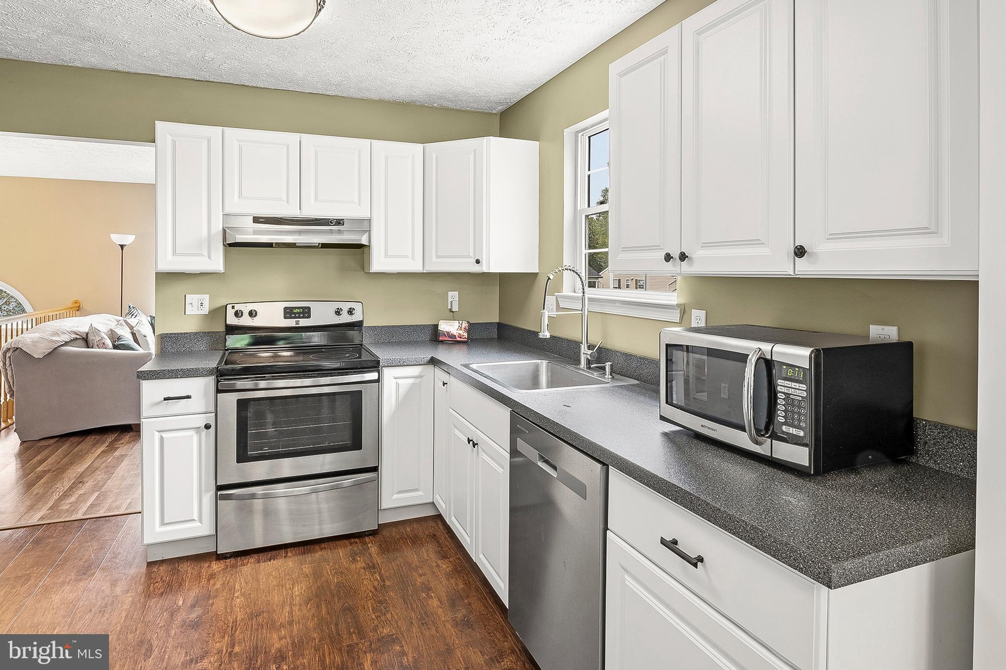 757 209th Street Pasadena, MD 21122 - Photo 6 of 32 a kitchen with stainless steel appliances granite countertop a sink stove and cabinets
