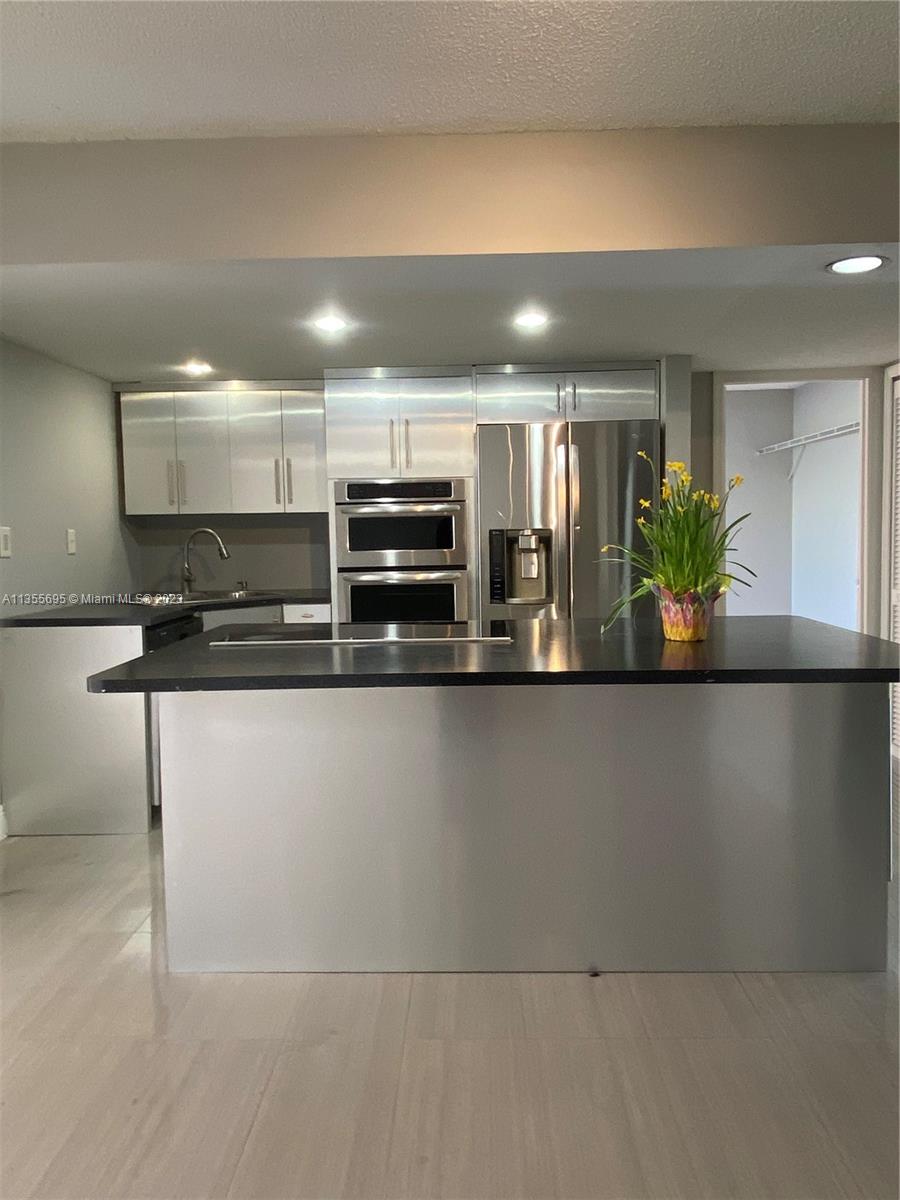 14661 Southwest 99th Street Miami, FL 33186 - Photo 2 of 14 a view of kitchen with refrigerator a microwave and furniture