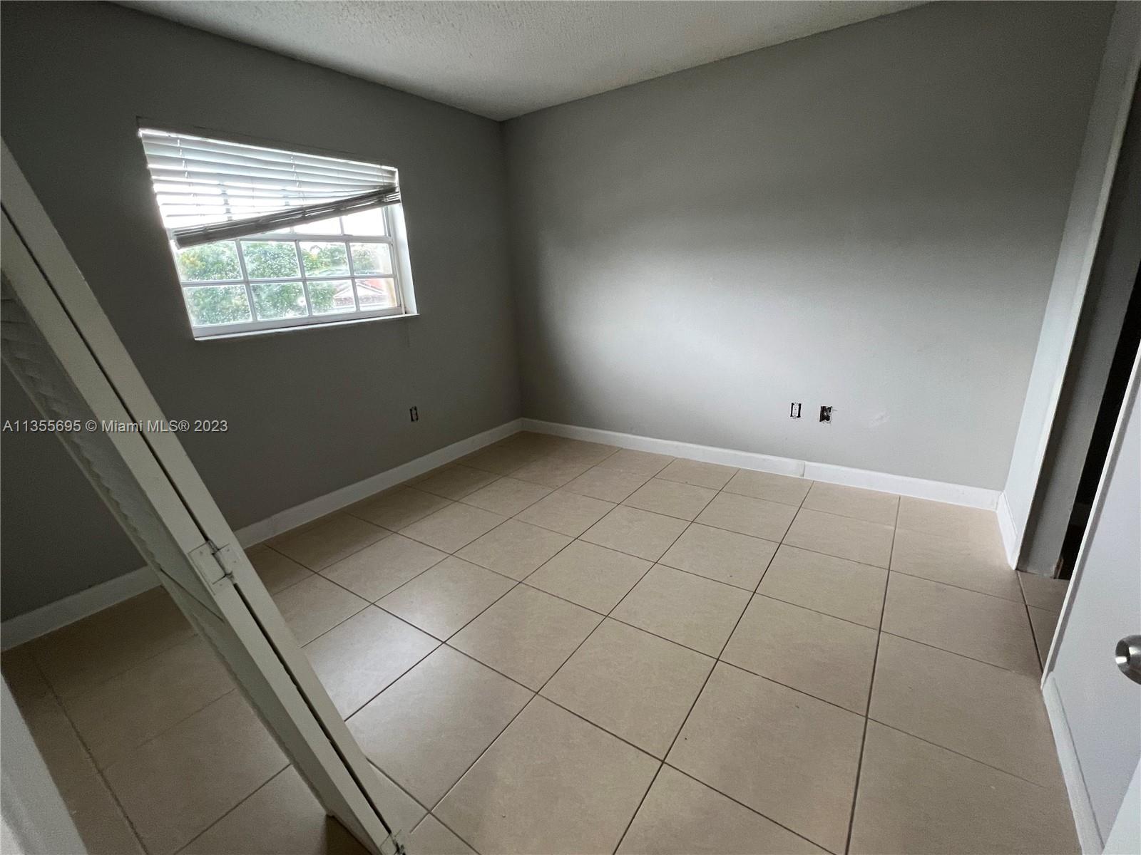 14661 Southwest 99th Street Miami, FL 33186 - Photo 7 of 14 a view of an empty room and window