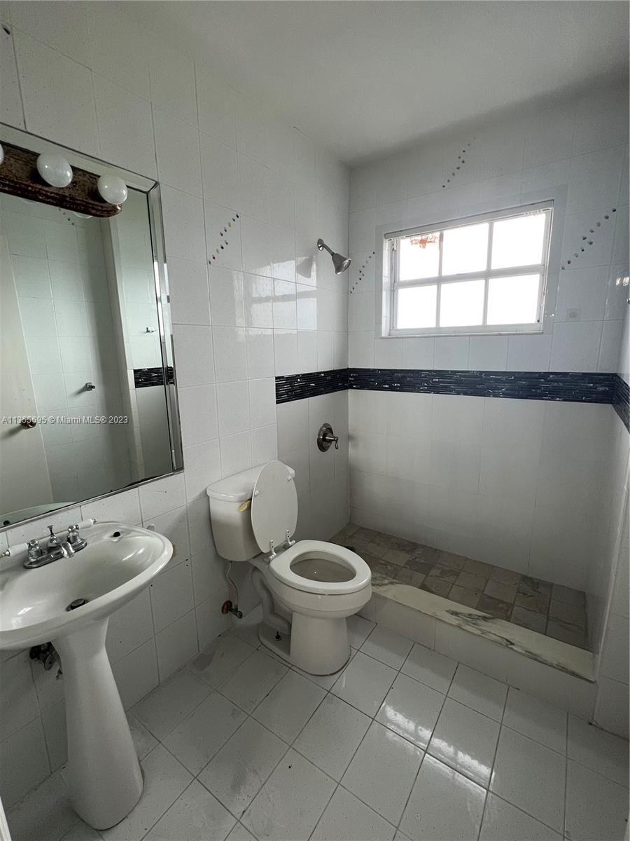 14661 Southwest 99th Street Miami, FL 33186 - Photo 8 of 14 a bathroom with a toilet sink and mirror