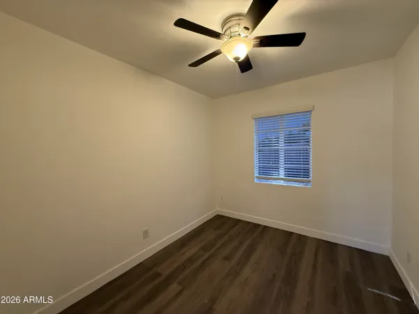 an empty room with a window and a ceiling fan