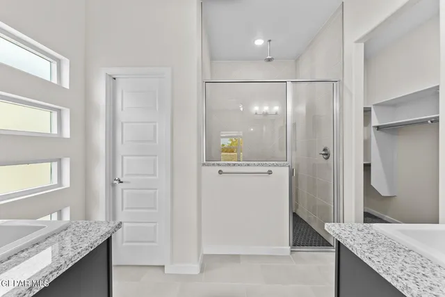a bathroom with a granite countertop sink and shower