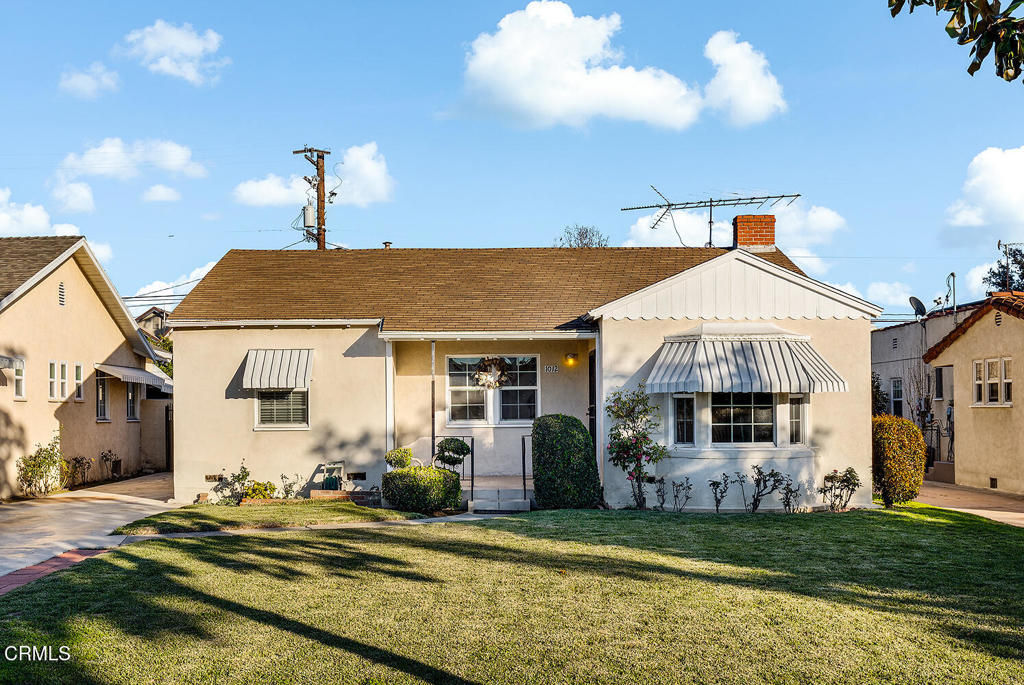 a front view of a house with a garden