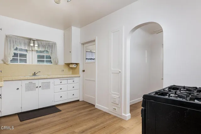 a kitchen with granite countertop white cabinets and black appliances