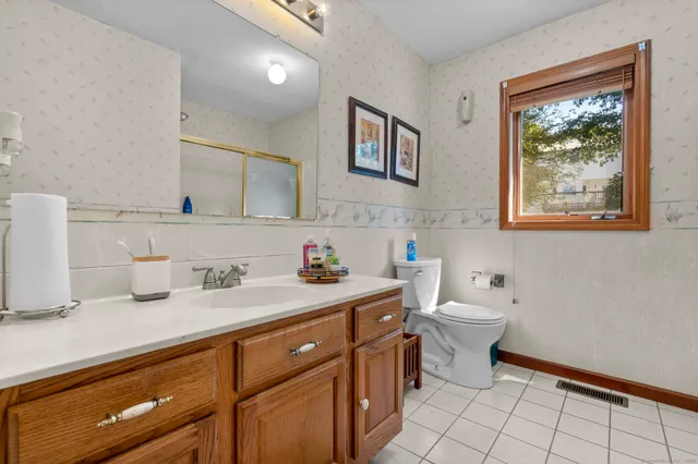 a spacious bathroom with a toilet sink and mirror