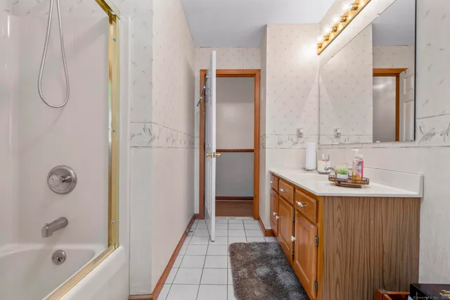a bathroom with a tub sink and mirror