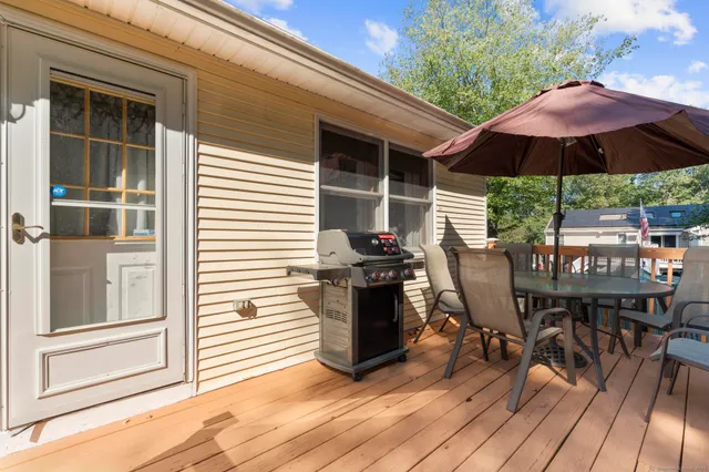 a view of a patio with table and chairs under an umbrella with wooden floor