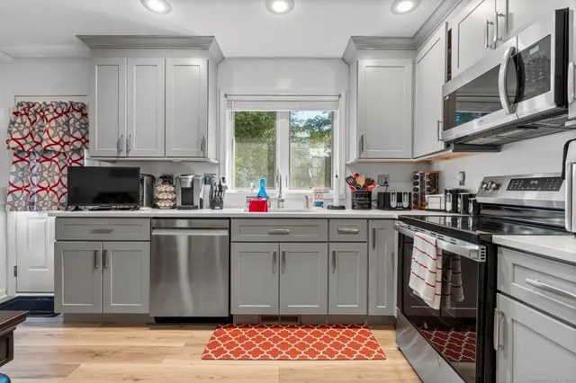 a kitchen with stainless steel appliances granite countertop a sink stove and cabinets