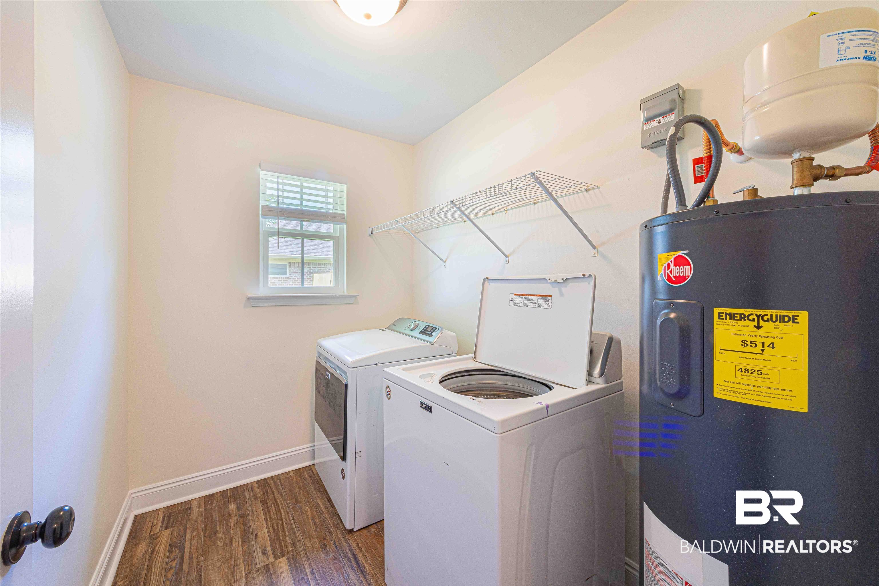 18675 Explorer Drive Loxley, AL 36551 - Photo 34 of 42 Laundry area featuring electric water heater, washer and clothes dryer, wood finished floors, and baseboards