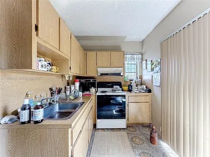 a kitchen with stainless steel appliances a sink a stove and a refrigerator