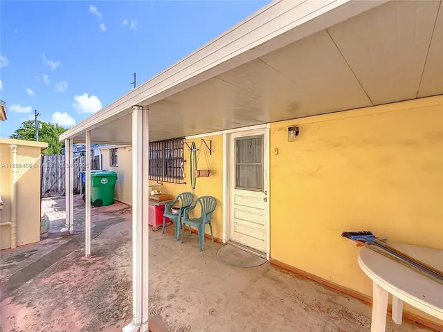 a backyard of a house with table and chairs