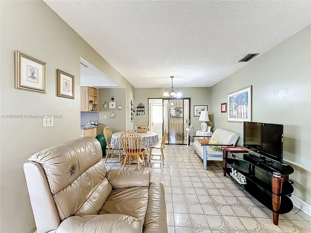 a living room with furniture and a dining table with rug kitchen