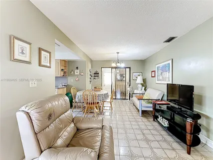 a living room with furniture and a dining table with rug kitchen