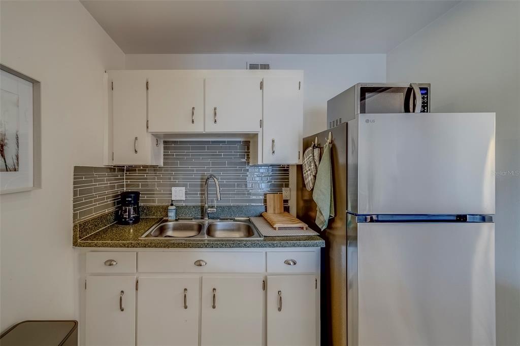 361 South McMullen Booth Road, Unit 112 Clearwater, FL 33759 - Photo 13 of 36 a kitchen with stainless steel appliances granite countertop a refrigerator and a sink