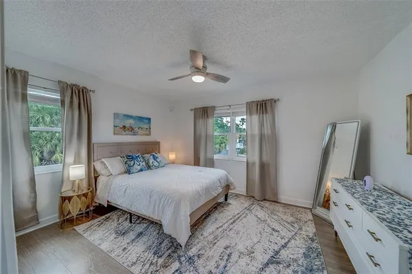 a bedroom with a bed flat screen tv and window