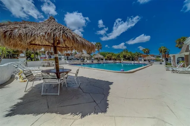 a view of a patio with dining table and chairs under an umbrella