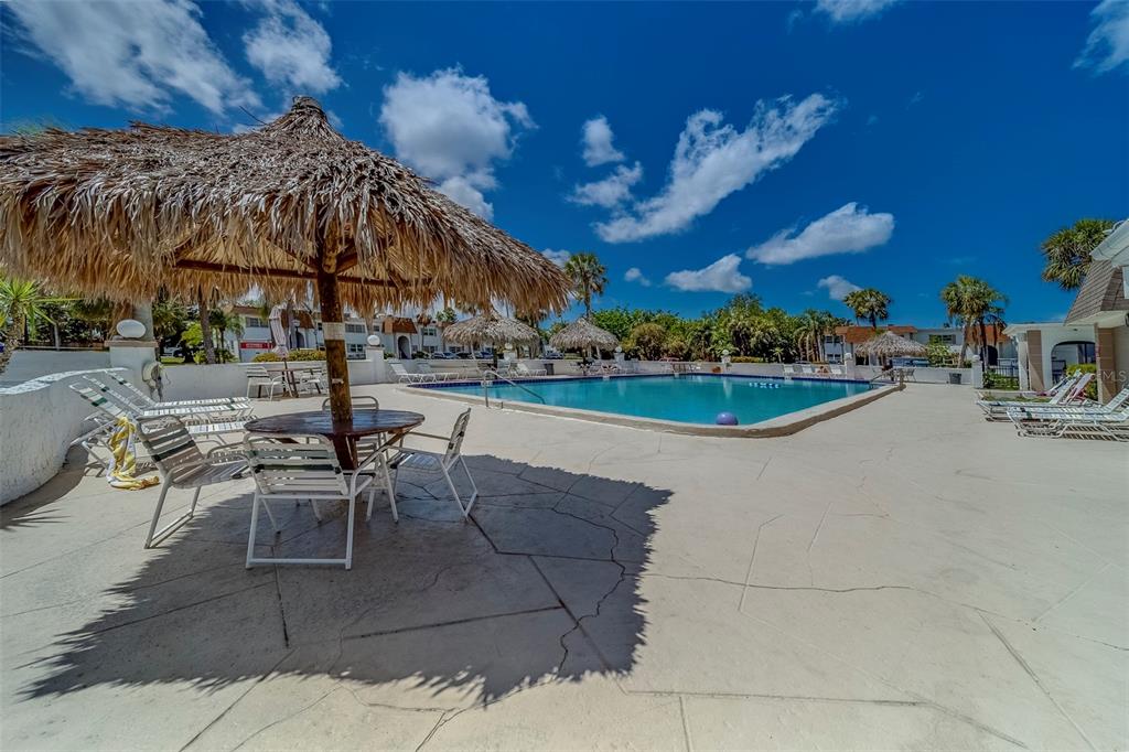 361 South McMullen Booth Road, Unit 112 Clearwater, FL 33759 - Photo 27 of 36 a view of a patio with dining table and chairs under an umbrella