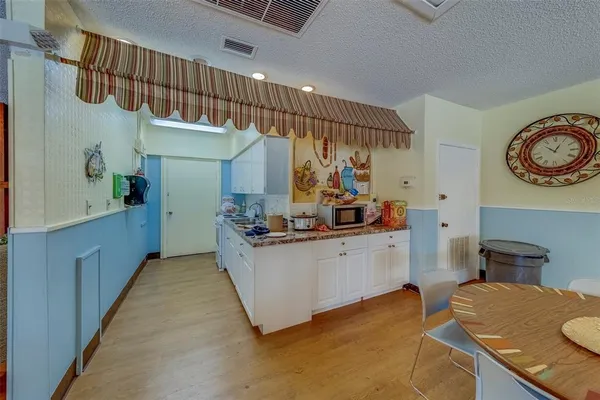 a kitchen with stainless steel appliances kitchen island a white cabinets and wooden floor