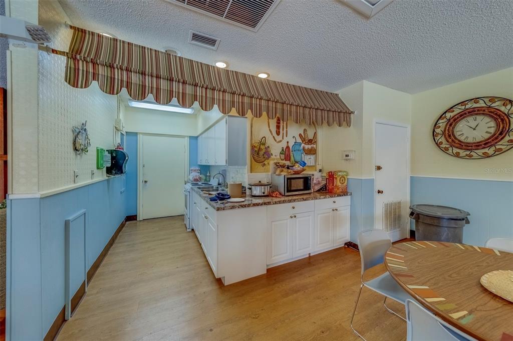 361 South McMullen Booth Road, Unit 112 Clearwater, FL 33759 - Photo 33 of 36 a kitchen with stainless steel appliances kitchen island a white cabinets and wooden floor
