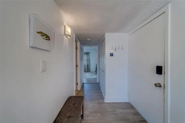 a view of a hallway with wooden floor and a bathroom