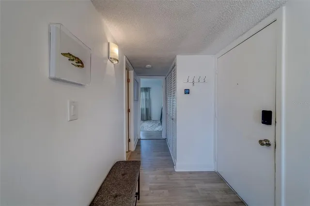 a view of a hallway with wooden floor and a bathroom