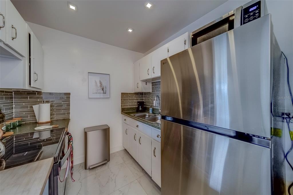 361 South McMullen Booth Road, Unit 112 Clearwater, FL 33759 - Photo 10 of 36 a kitchen with stainless steel appliances granite countertop a refrigerator and a stove