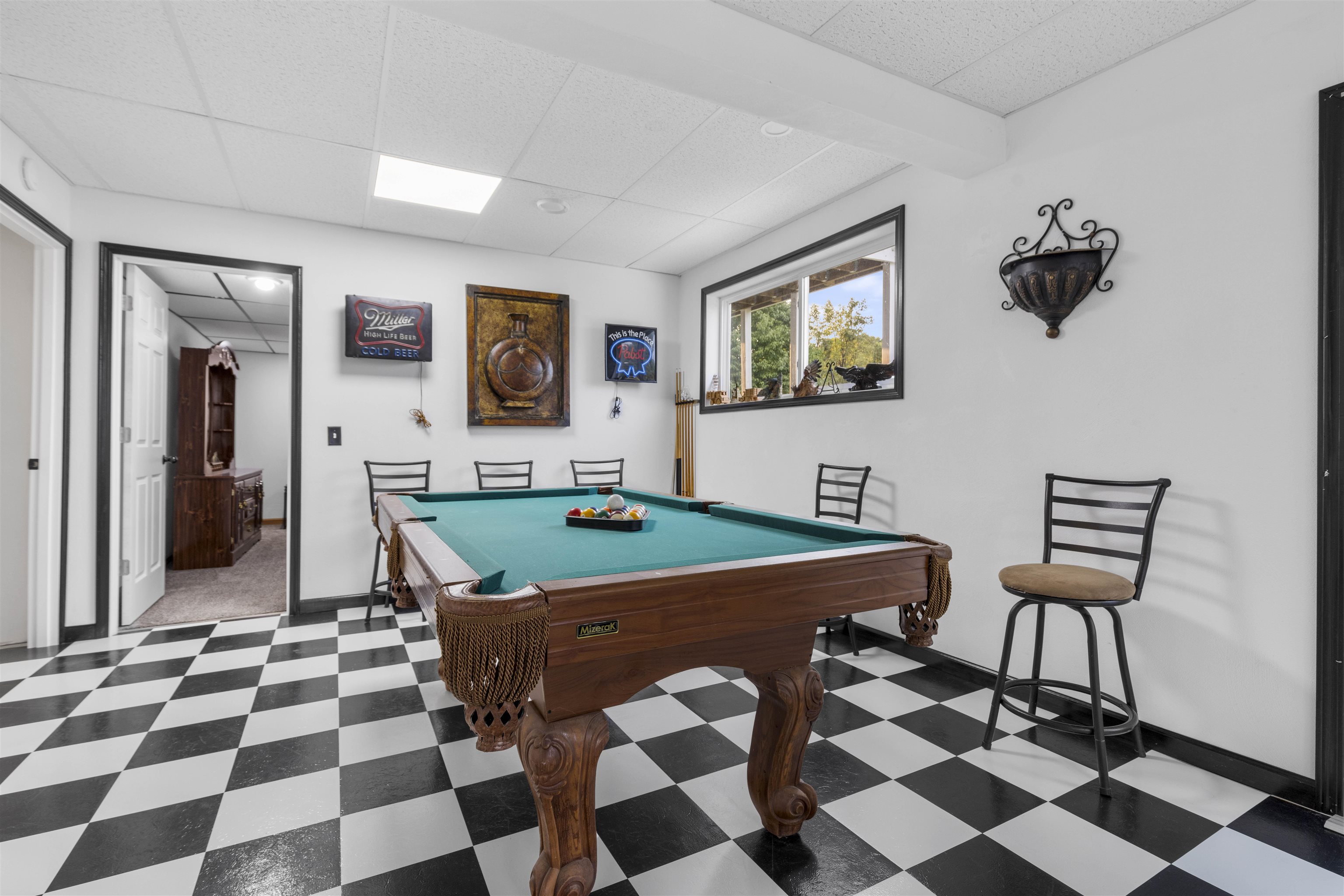 4524 East River Road Ridott, IL 61067 - Photo 19 of 28 a living room with a black white checkered floor with a gaming machine and dining chairs