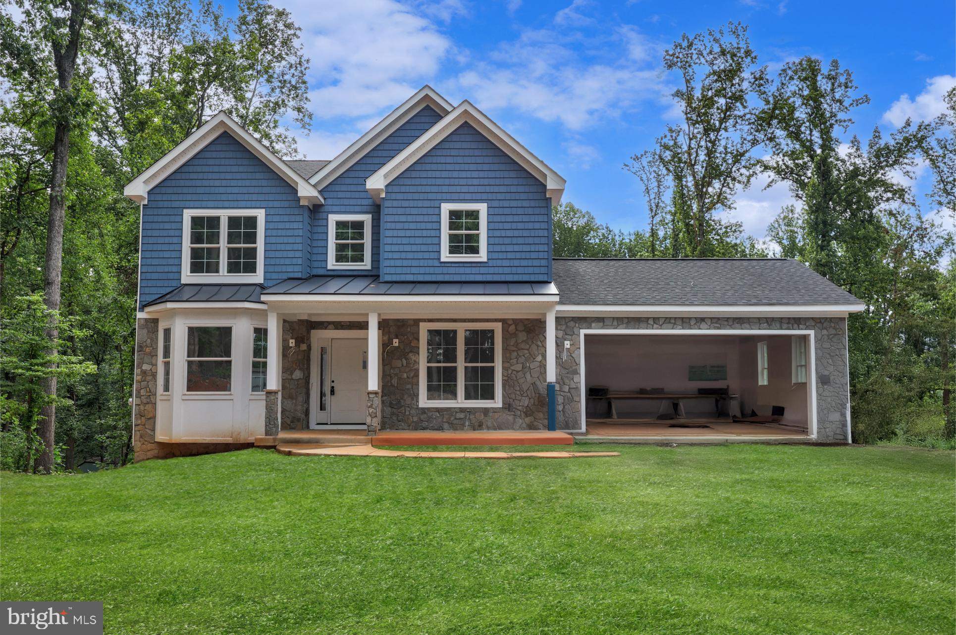 a view of a house with a yard and a large tree