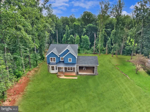 an aerial view of a house with backyard garden and outdoor seating