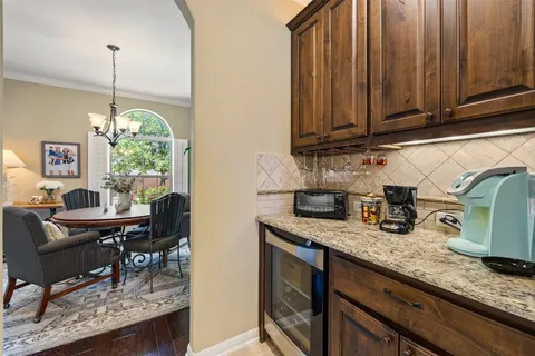 a kitchen with granite countertop a sink a counter space dining table and chairs