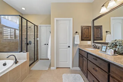 a spacious bathroom with a double vanity sink mirror and shower