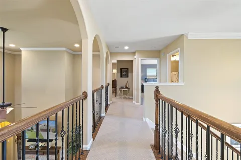 a view of a hallway with wooden floor and windows