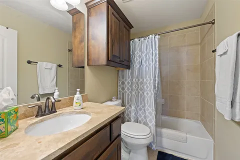 a bathroom with a granite countertop sink toilet and shower