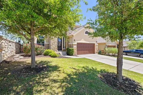 a view of a house with backyard and a tree