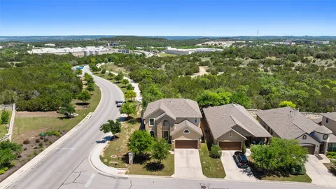 an aerial view of residential houses with outdoor space and street view