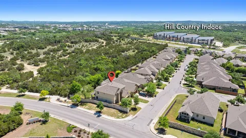 an aerial view of residential houses with outdoor space and ocean view