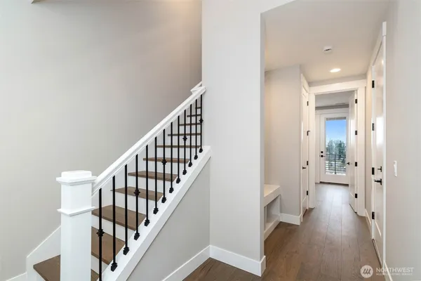 a view of a hallway with wooden floor and staircase