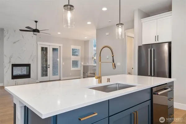 a kitchen with a sink a refrigerator and a fireplace