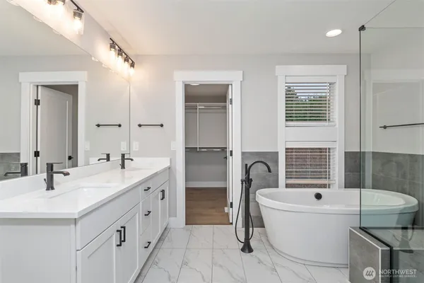 a bathroom with a tub sink and mirror