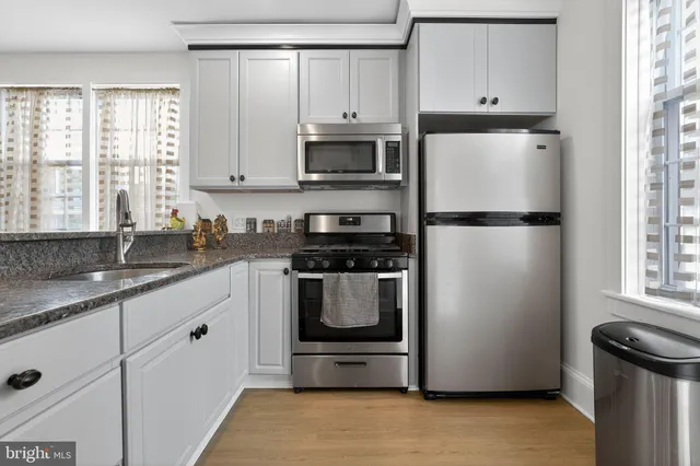 a kitchen with refrigerator a stove a sink and cabinets