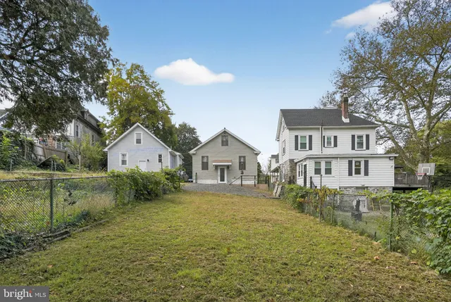 a front view of a house with a yard and trees