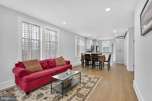 a living room with furniture potted plant and a large window