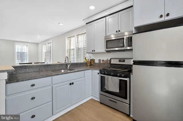 a kitchen with stainless steel appliances granite countertop a stove and a microwave