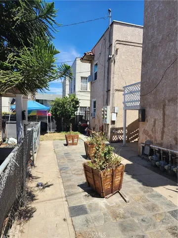 a view of a patio with couches and table and chairs and potted plants