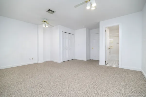 an empty room with chandelier fan