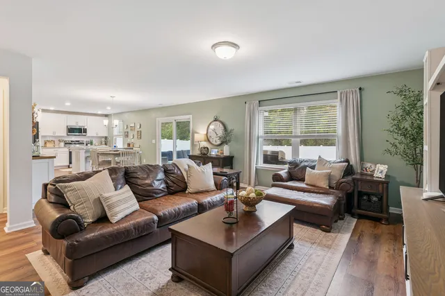 a living room with furniture and view of kitchen