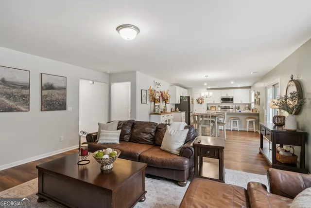 a kitchen with stainless steel appliances kitchen island granite countertop a table chairs sink and cabinets